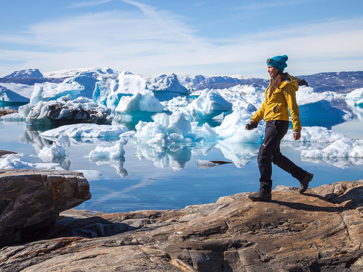 Hiker walking along the shore of Greenland