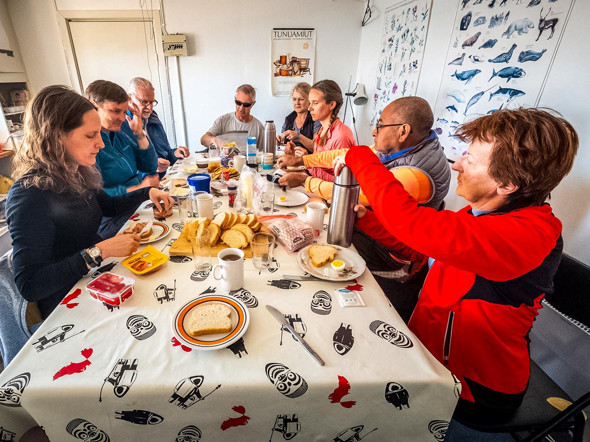 Trekking tour group stops for meal at local remote village hut