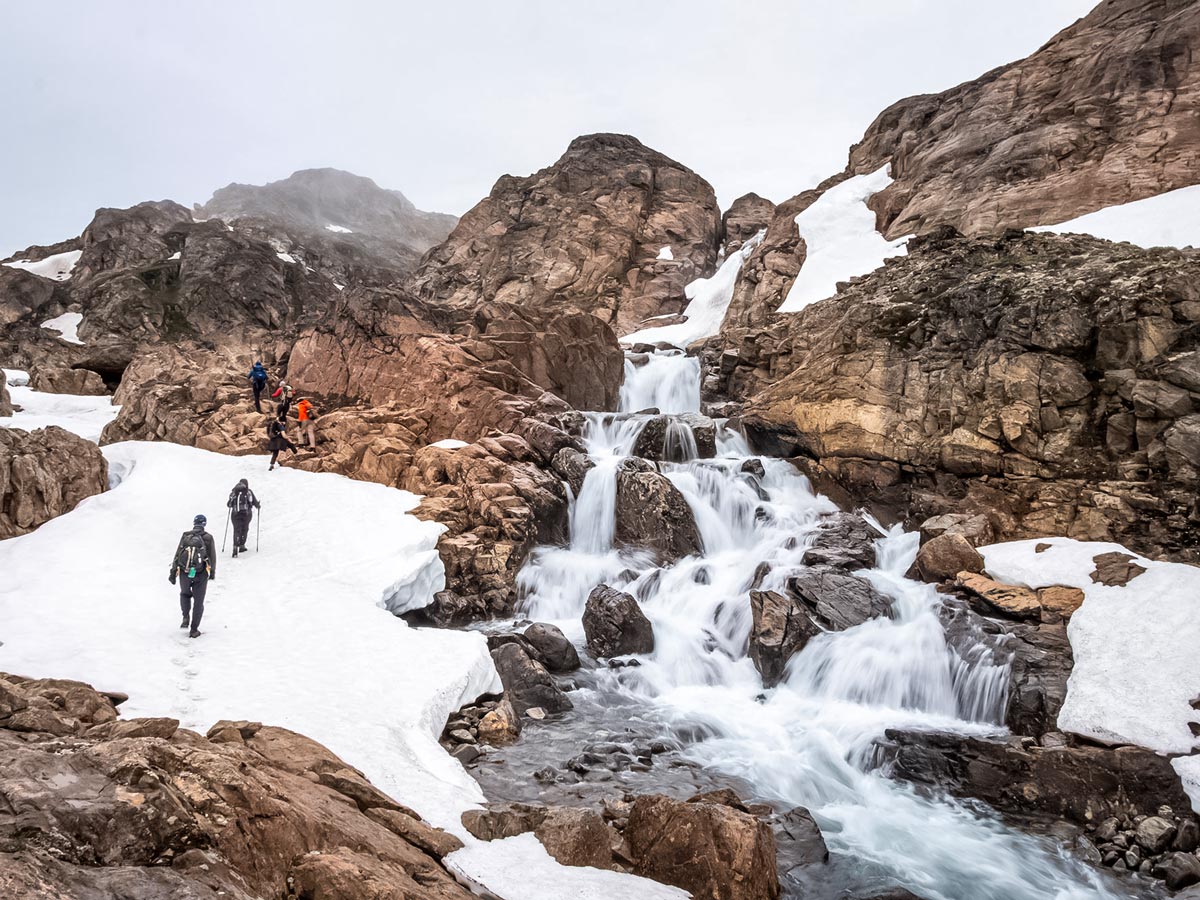 Hiking alongside stunning waterfalls freezing ice water hiking in Greenland