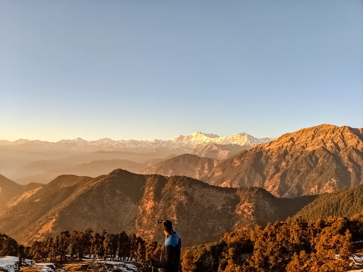 Uttarakhand toursit hiker takes photos of flowers of the valley trek India