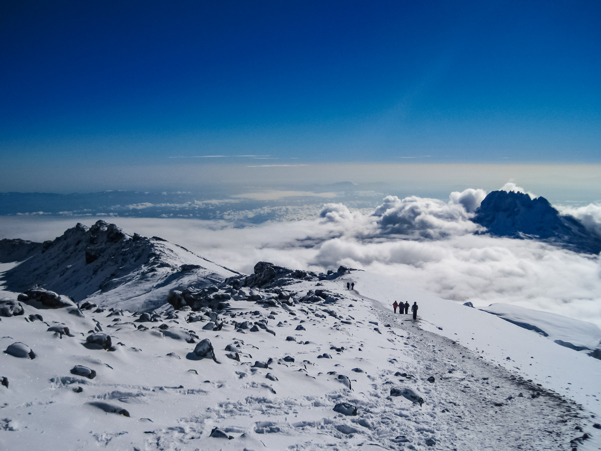 Hikers at snow covered summit hiking Lemosho trail Mount Kilimanjaro Tanzania