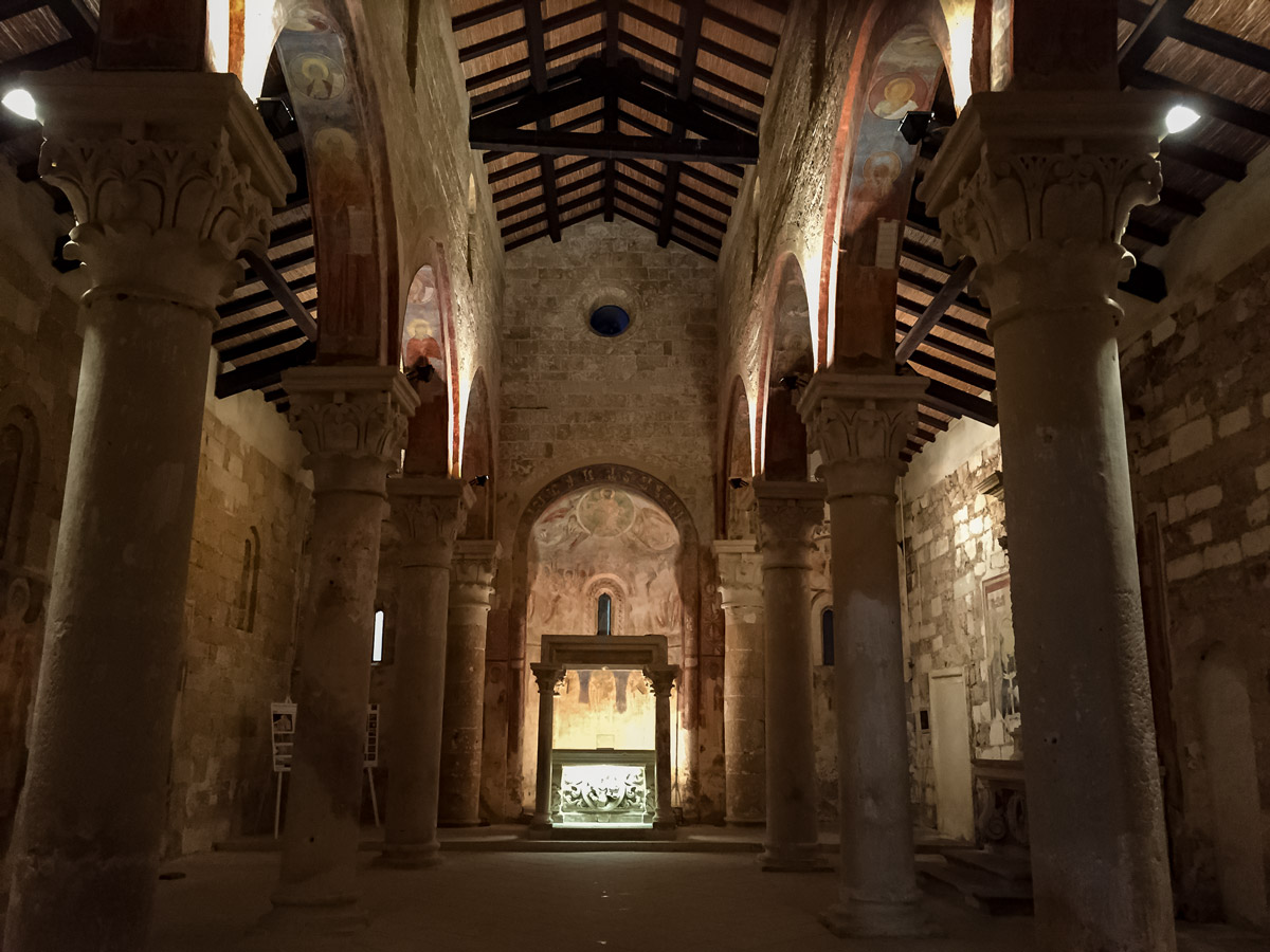 Looking inside Abbey of Cerrate old stone church chaple along cycling tour Italy