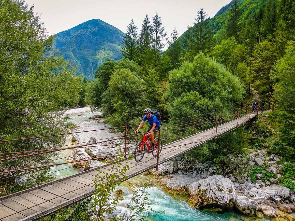 Biking tour Slovenia happy trails biker crosses bridge