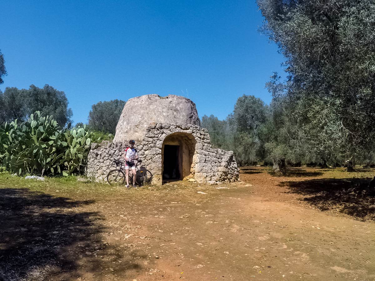 Old trullo and cacti seen cycling Itria Valley Italy bike tour