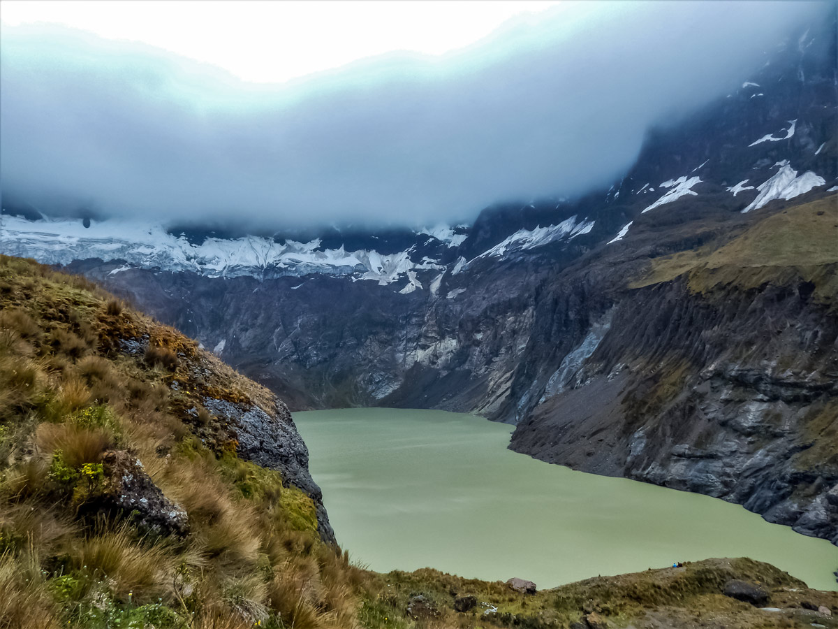 Clouds hanging over lake hiking trekking altar volcano Peru