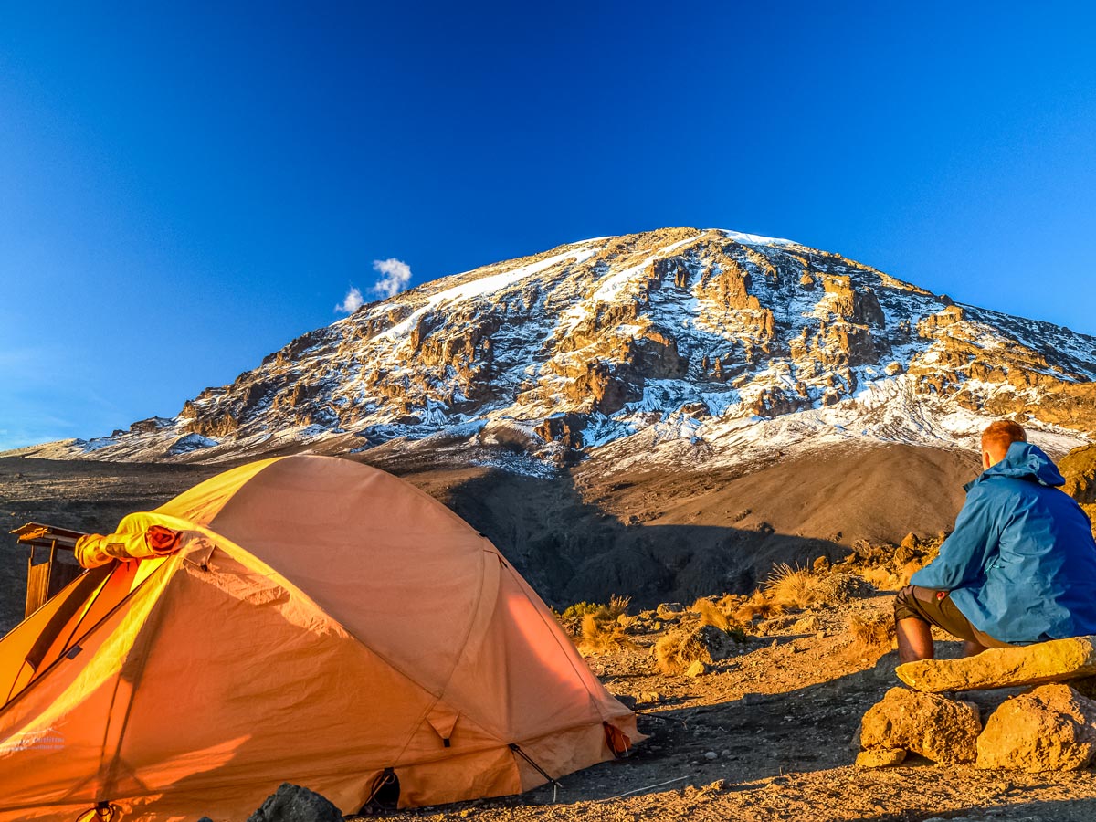 Hiker camping at Mount Kilimanjaro basecamp along trekking tour Tanzania