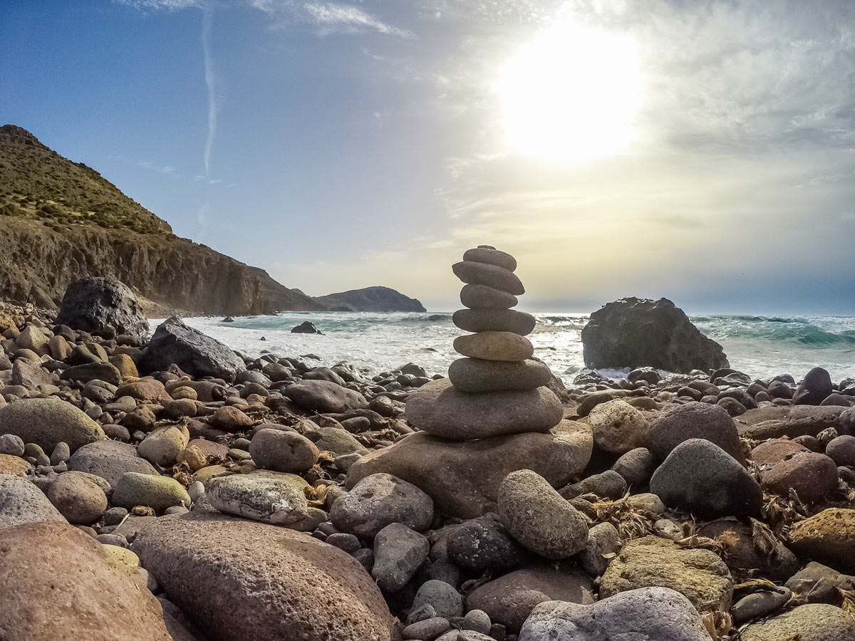 Stacking rock towers by the ocean hiking walking trekking tour Spain