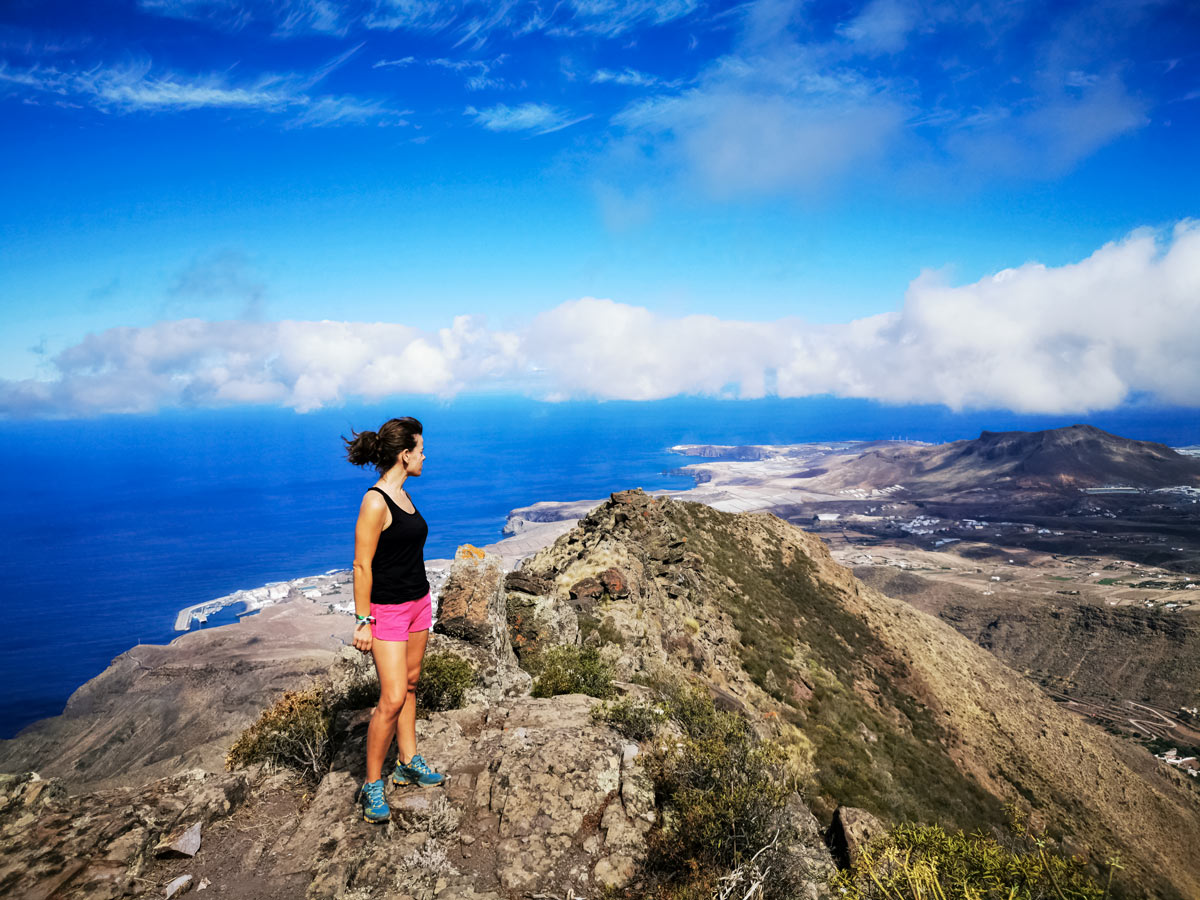 Hiker atop coastal mountain hiking Spain