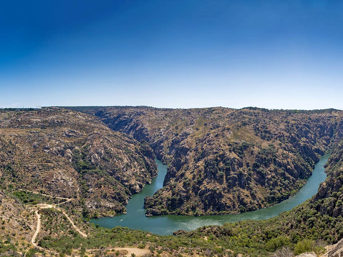 Winding road to river canyon bottom Douro National Park adventure tour Portugal