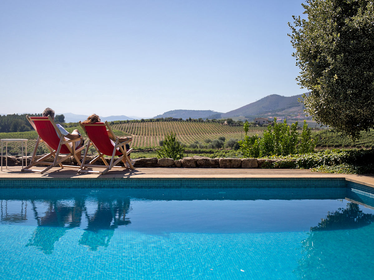 Relaxing by vineyard pool Douro wine region Portugal hiking