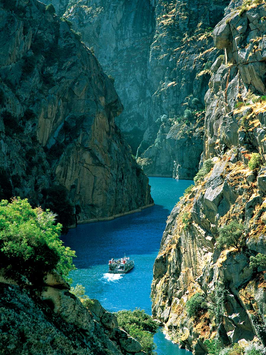 Boat ship in gorge fjord between rock cliffs