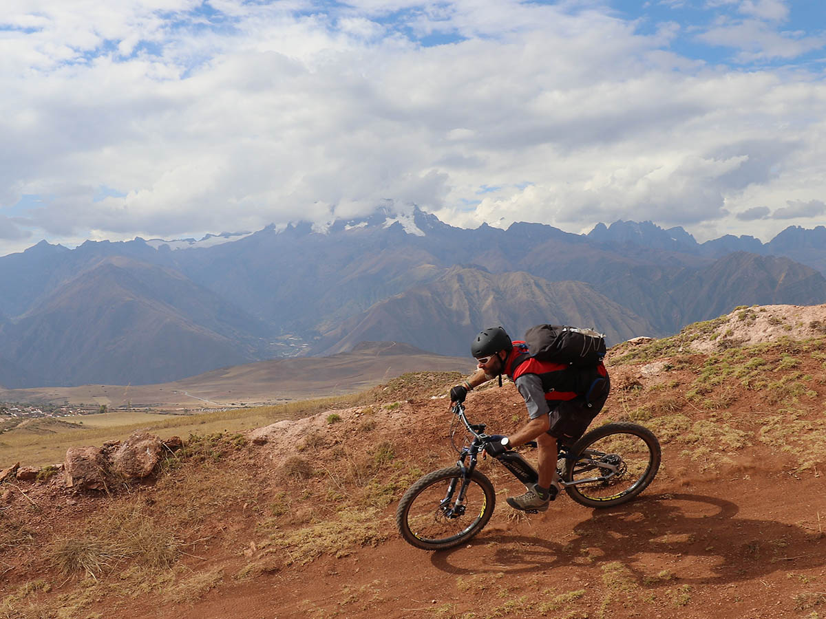 Cyclist biking down on a gravel path in Peru