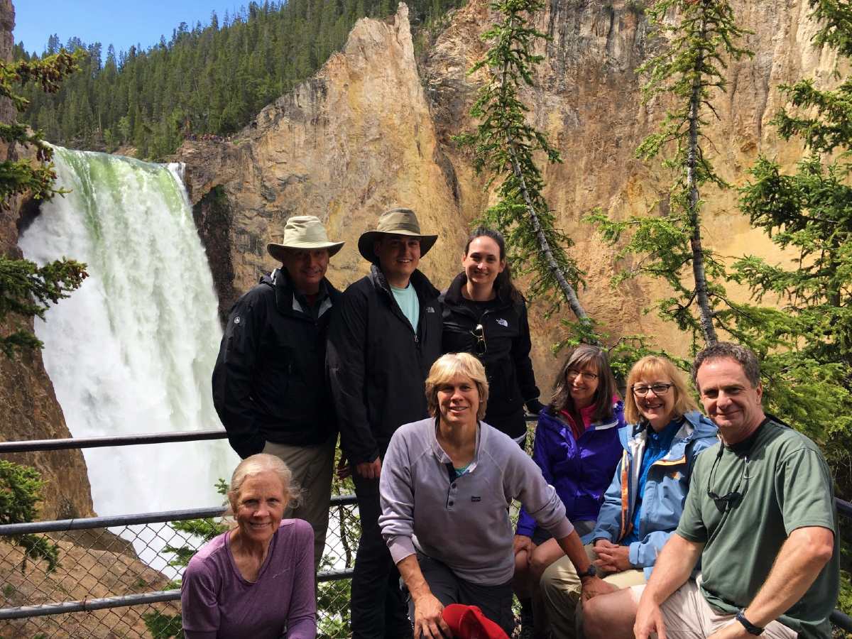 Group of hikers posing in front of the waterfall
