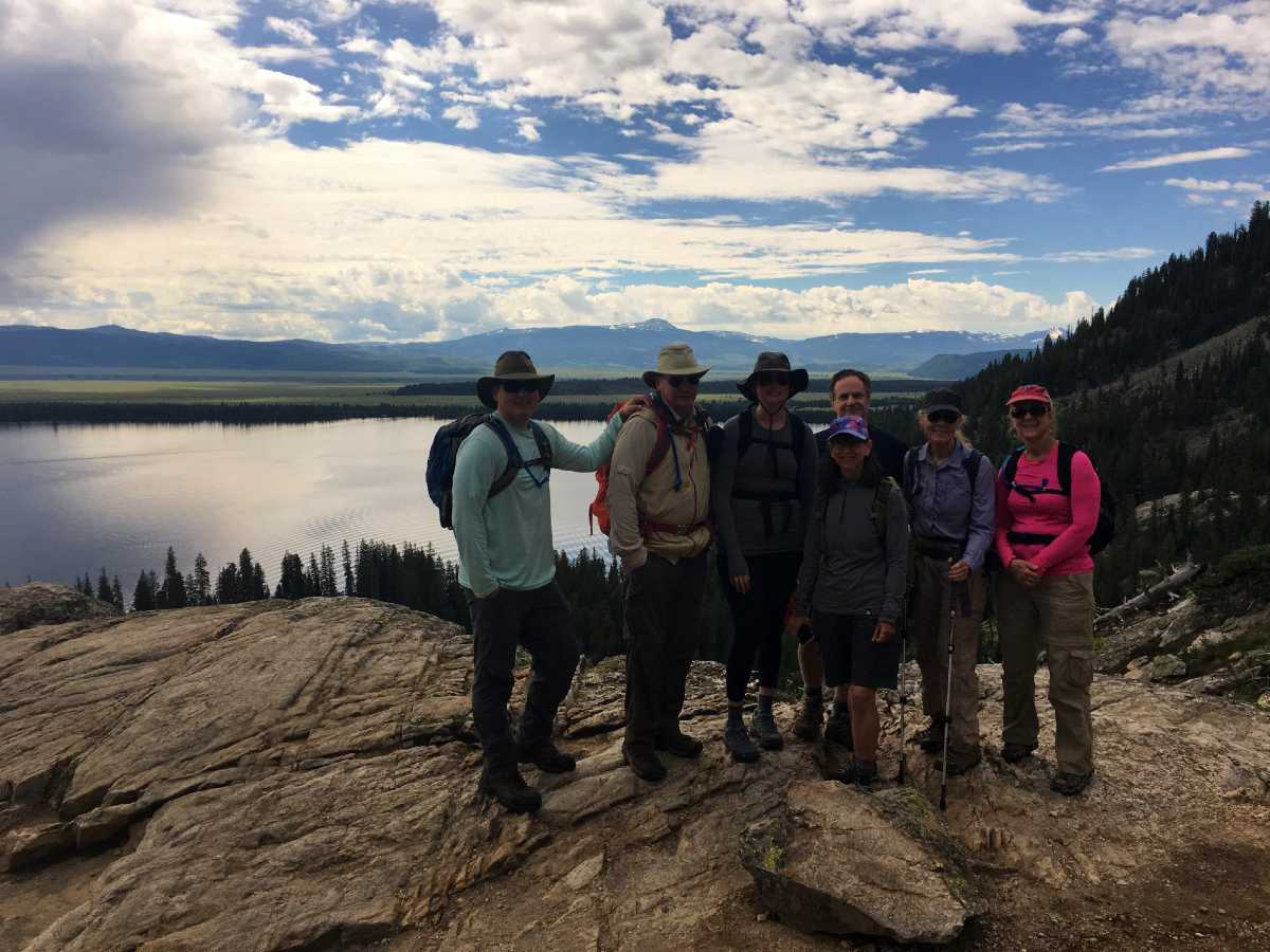 Group of hikers posing in front of the lake in Yellowstone
