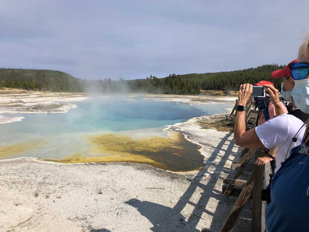 Group of tourists taking pictures of the geysers in Yellowstone