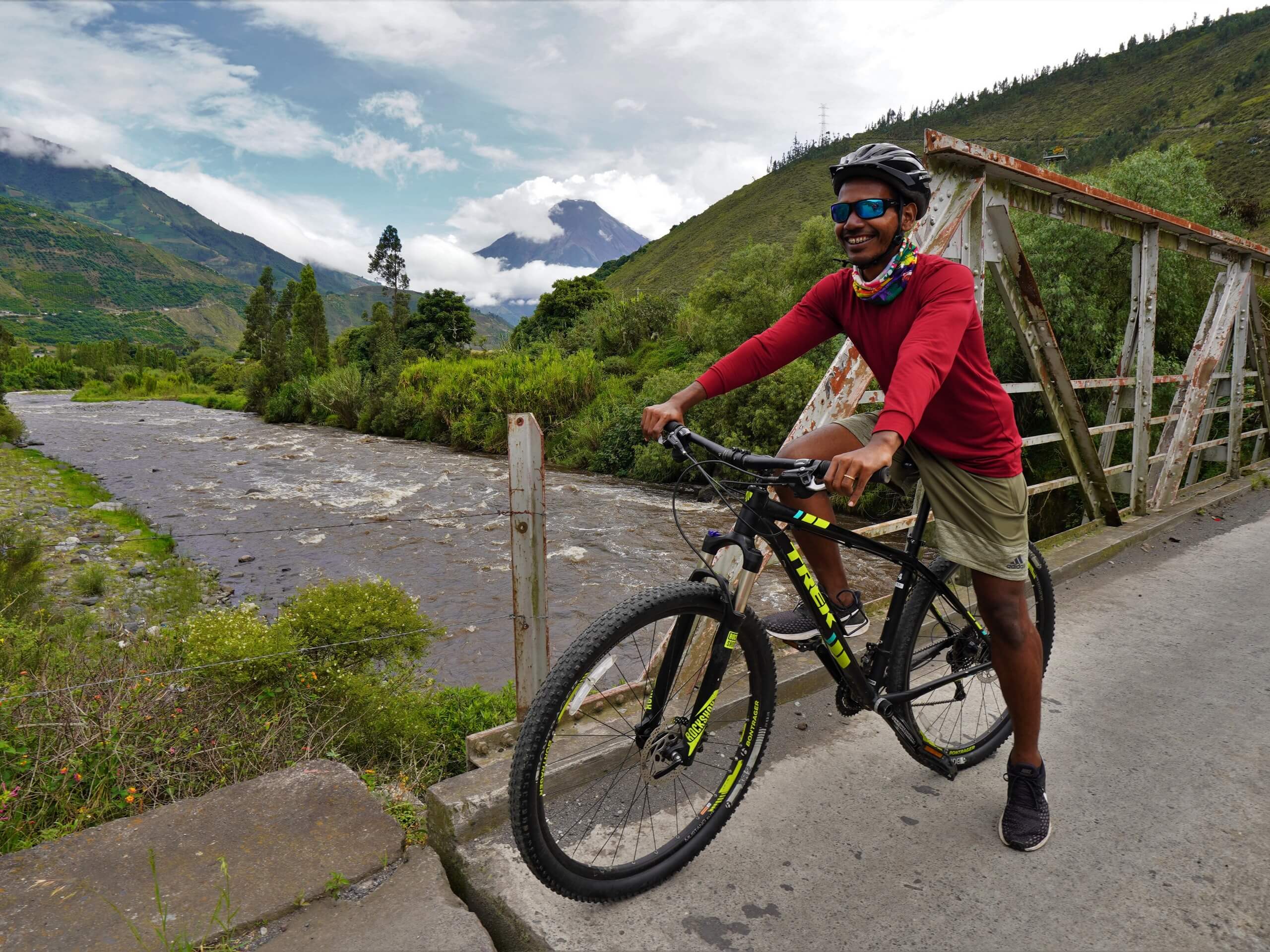 Biker crossing the bridge over the river near Banos