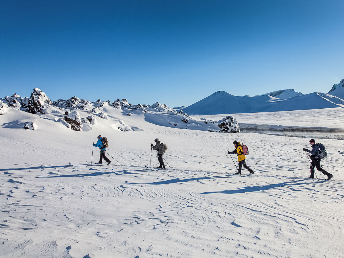 Four skiers traverse ice field tundra Landmannalaugar cross country nordic ski trek