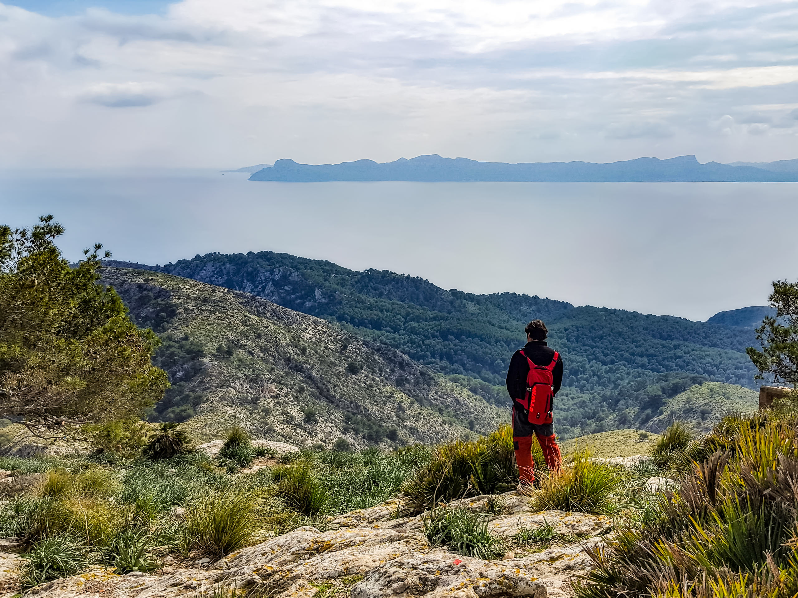 Alcudia hiker on the moutnains looking out to ocean mediterranean sea walking around Mallorca Spain