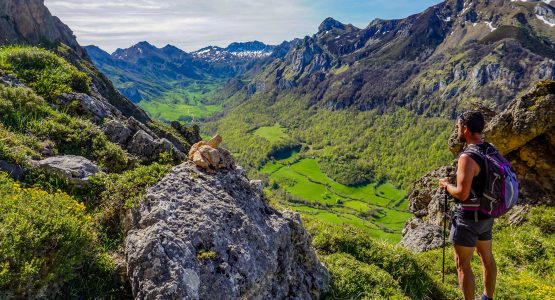 Hikers admiring view of green valley hiking in Spain Asturias walking circular lagos