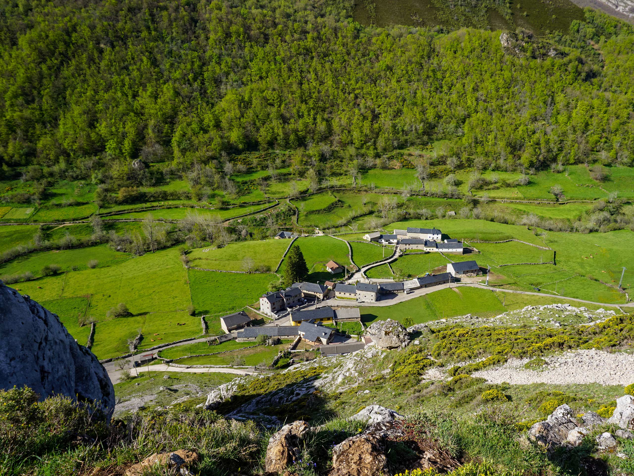 Looking down on farm houses small village in the mountain valley circular lagos hiking in Spain Asturias walking circular lagos