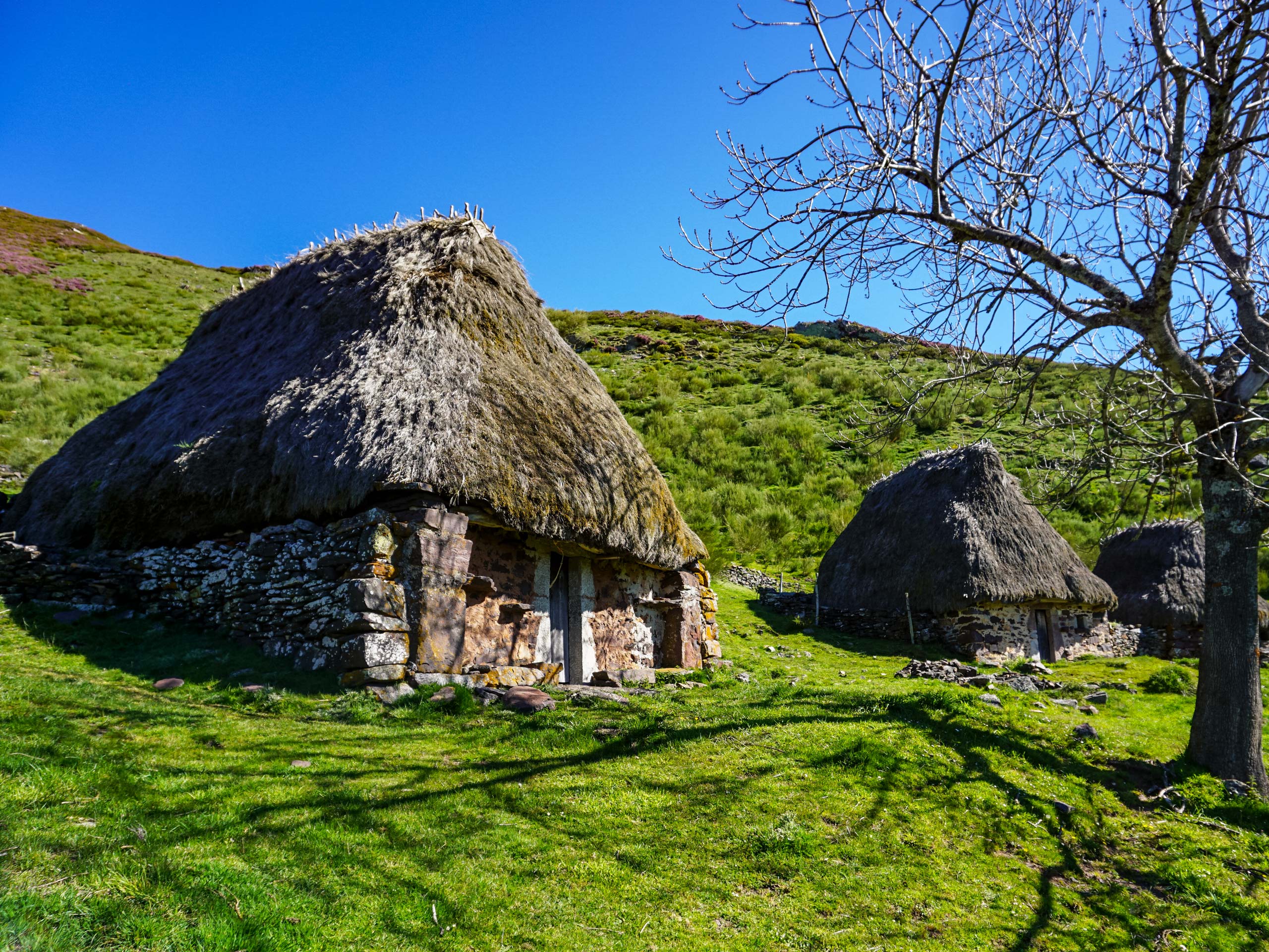 Old stone hut houses with grass roof hiking in Spain Asturias walking circular lagos