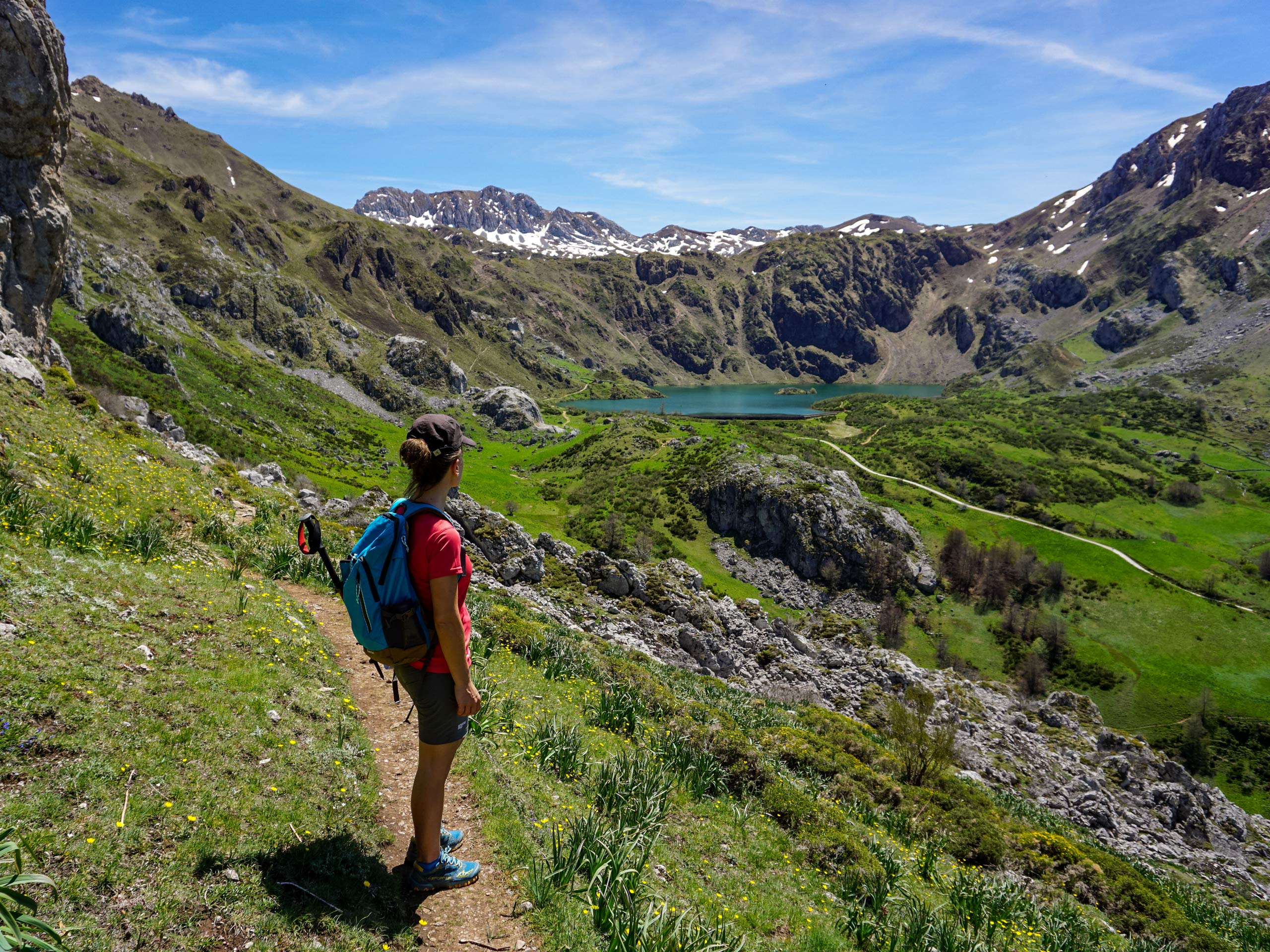 Trail wrapping around mountain side toward alpine lake hiking in Spain Asturias walking circular lagos