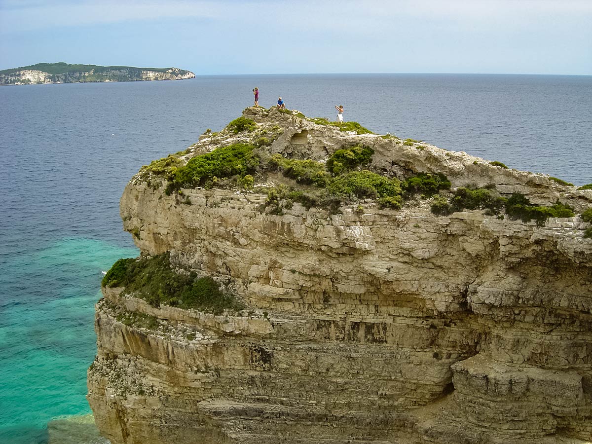 Hikers cross natural rock bridge Mediterranean Sea Corfu Paxos Greece adventure tour