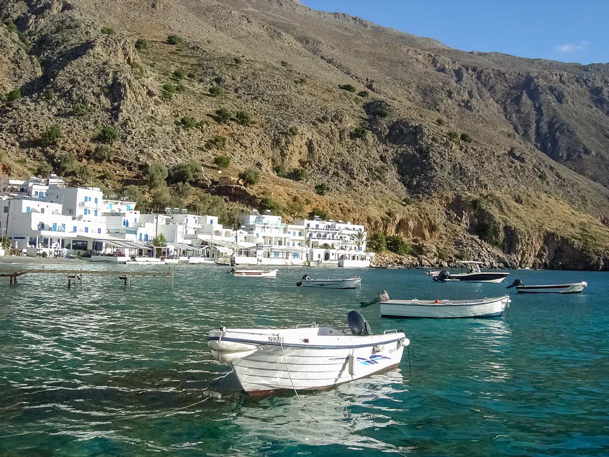 Boats in mediterranean cove bay kids family adventure tour Crete Greece