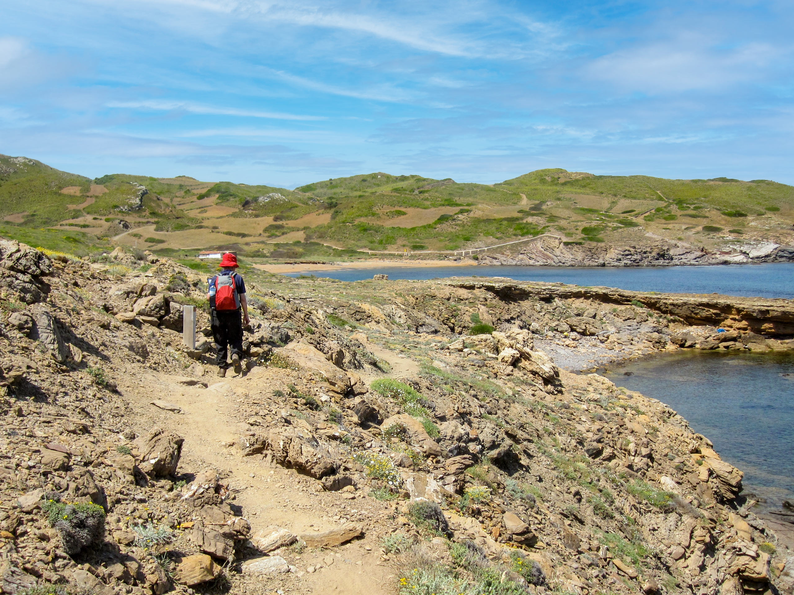 Walker along cala path by the ocean walking tour Menorca Spain