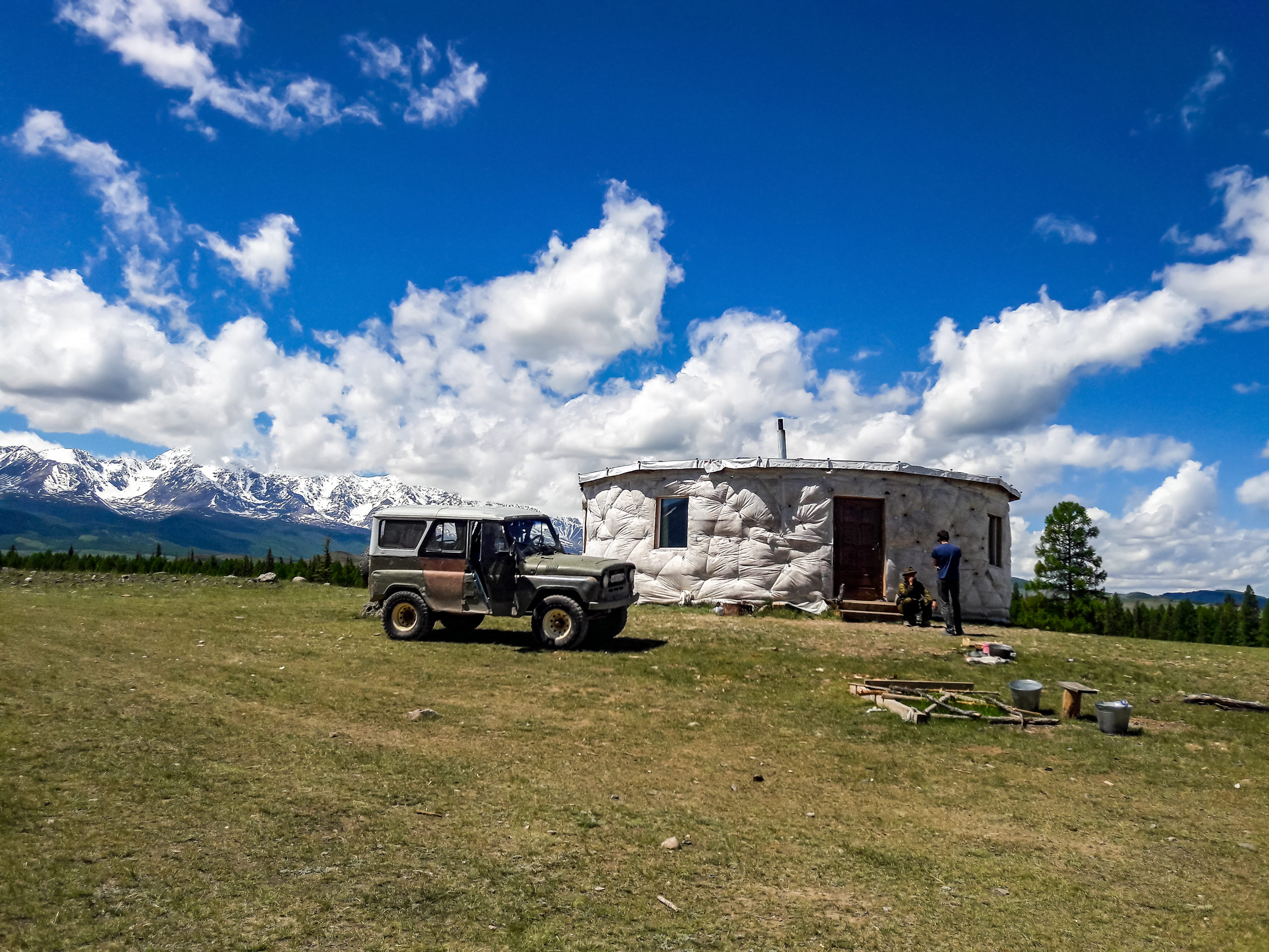 Safari jeep all terrain vehicle parked beside yurt shelter in Altai mountains Russia