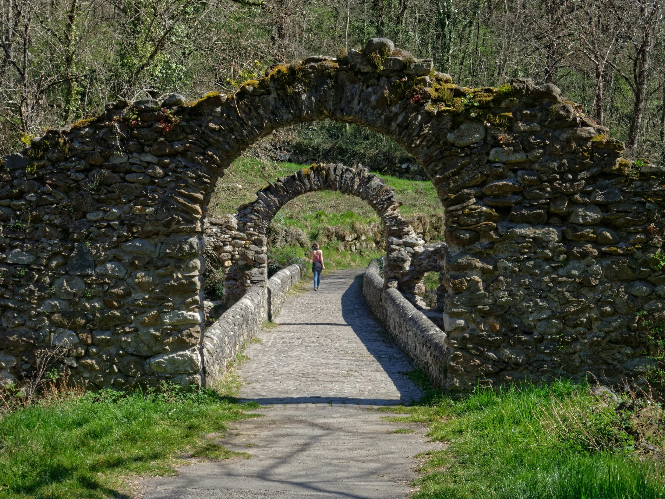 Lady crossing the rocky bridge in Provence