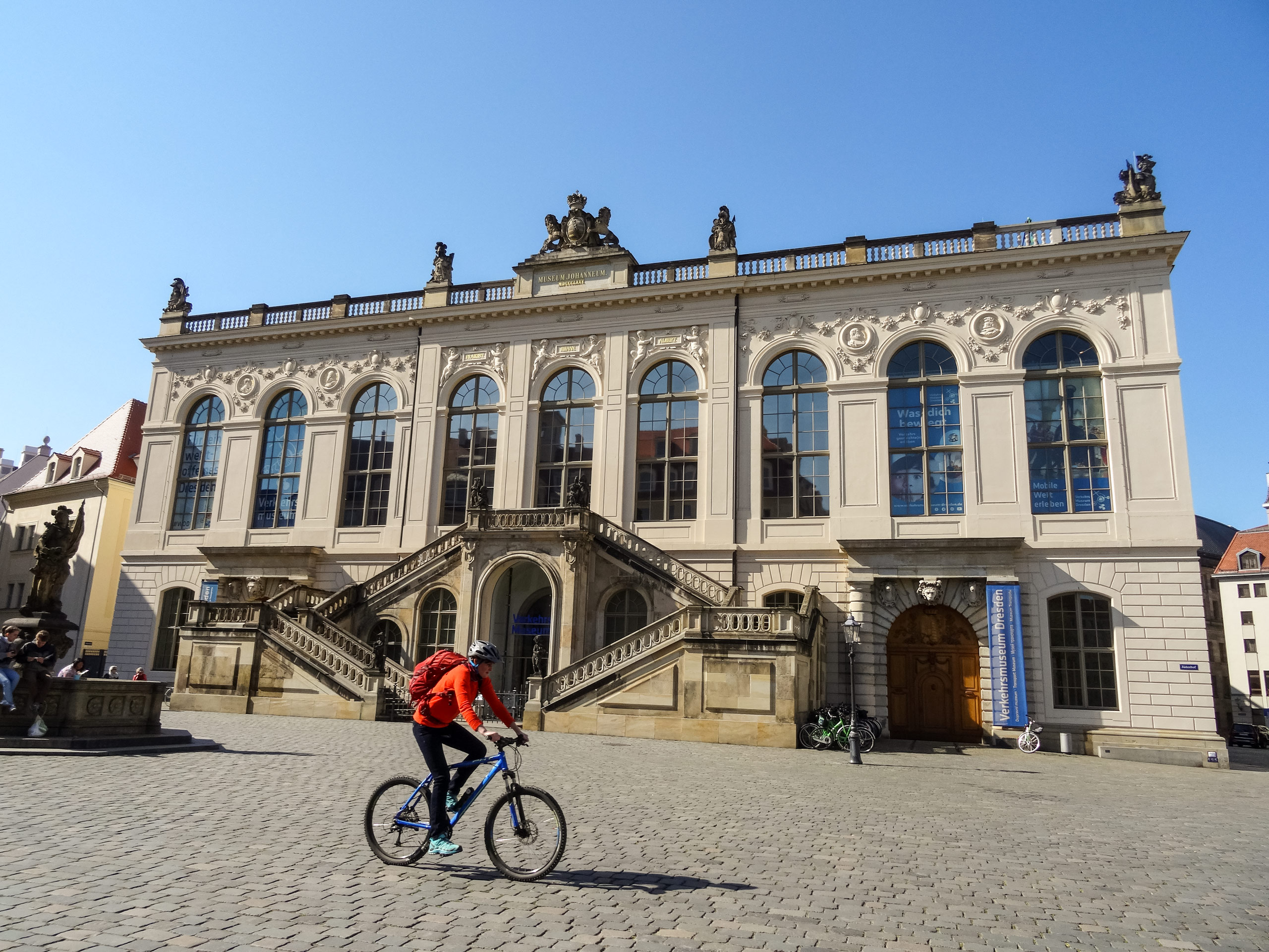 Cyclist biking in front of Transport Museum Johanneum Dresden