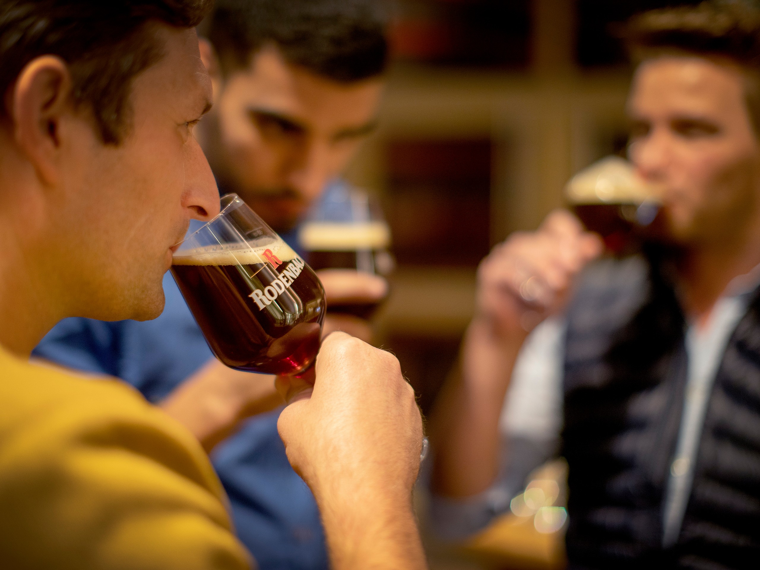 Three friends tasting beer while on cycling tour in Flanders