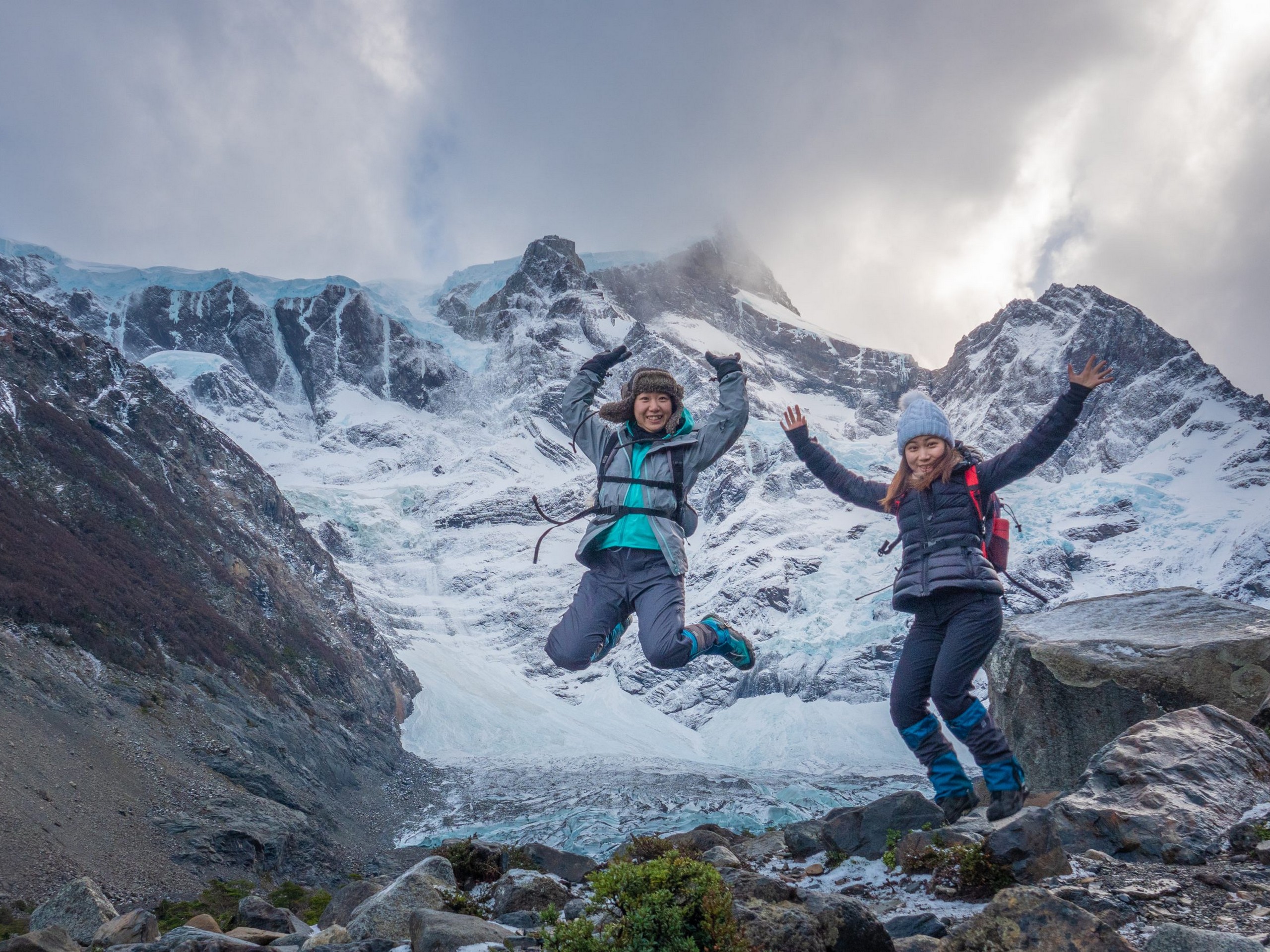 Two girls posing in front of a massive glacier on W Trek