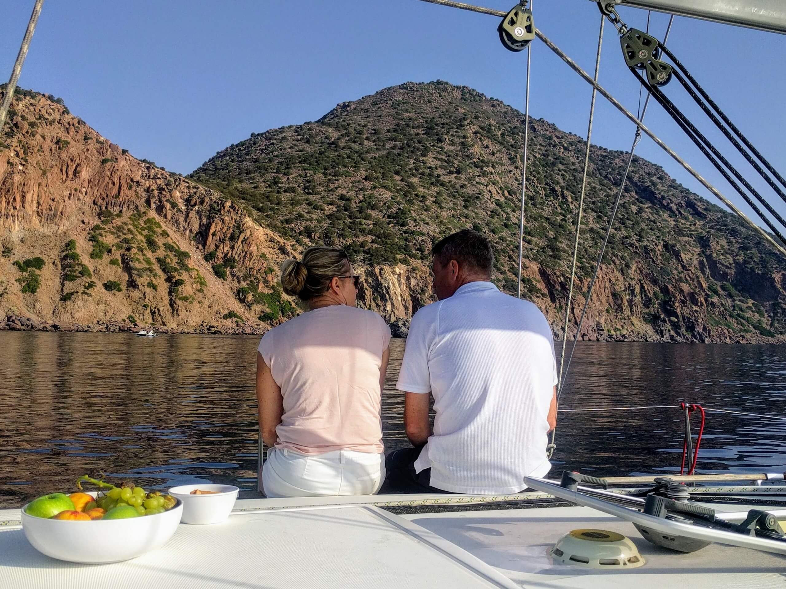 Couple sitting on a sailing boat near Aegina Island shores