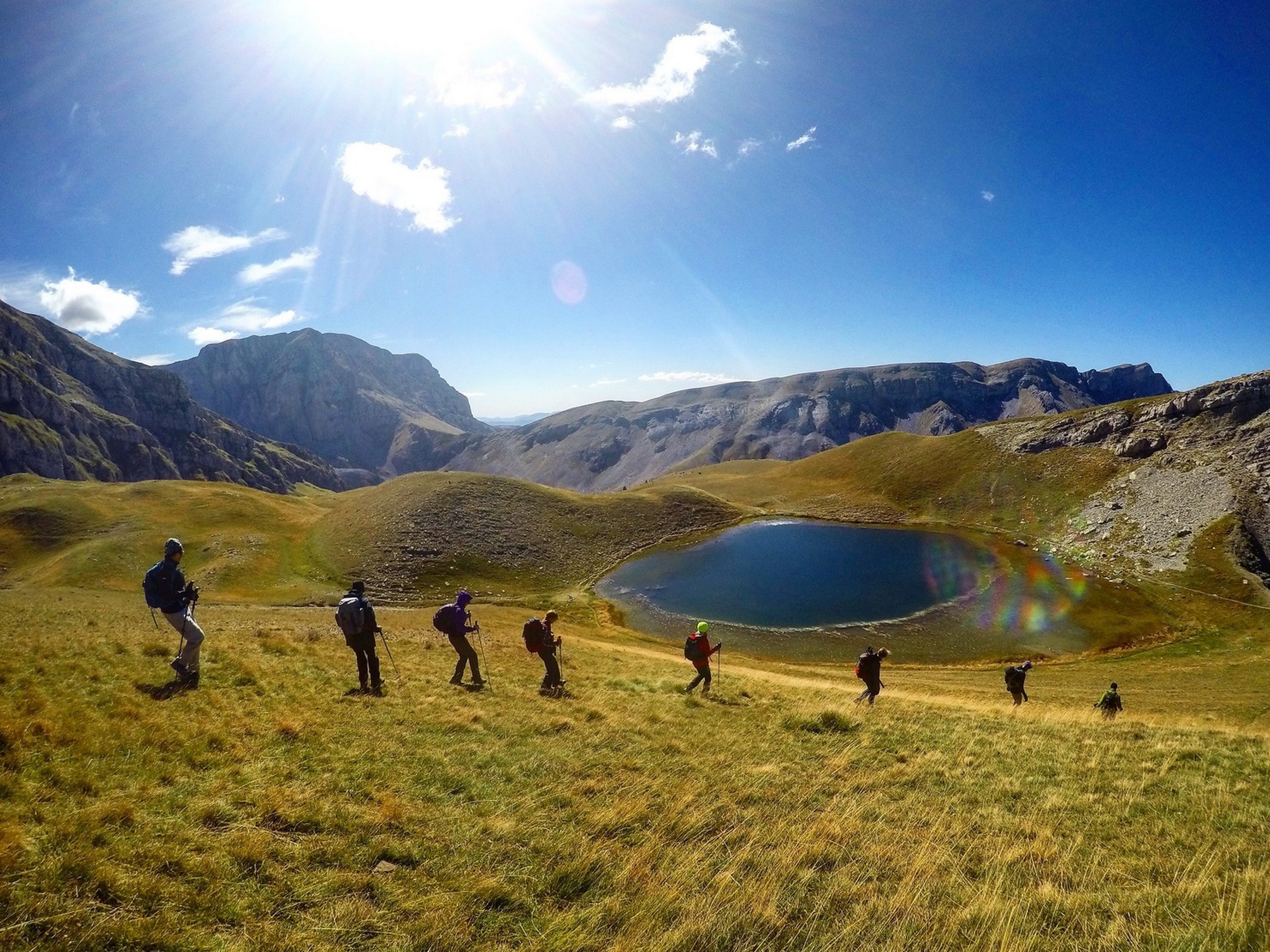 Group of hikers walking along the Drakolimni (Dragon) Lake in Greece