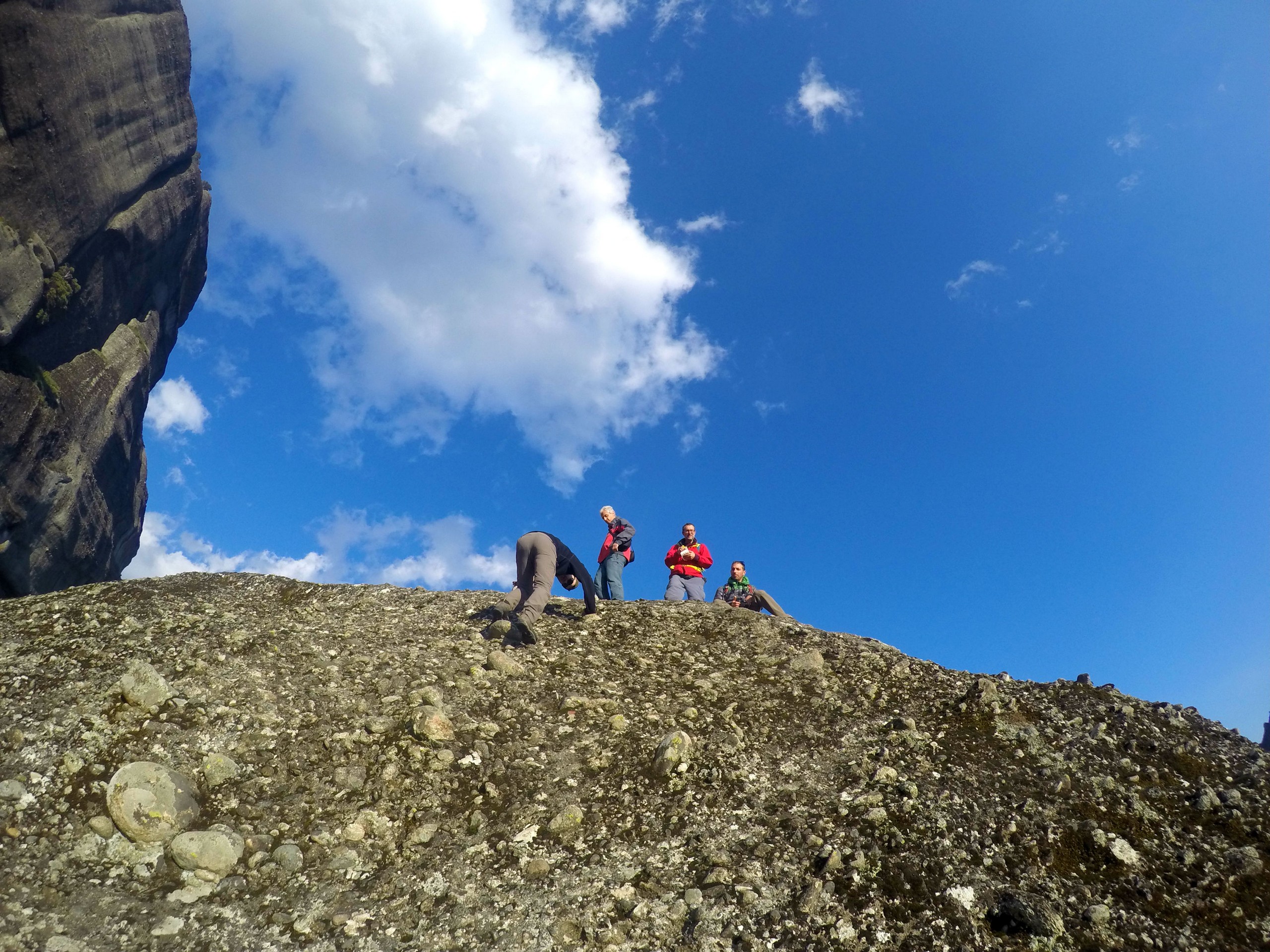 Group of hikers climbing on rocks in Meteora