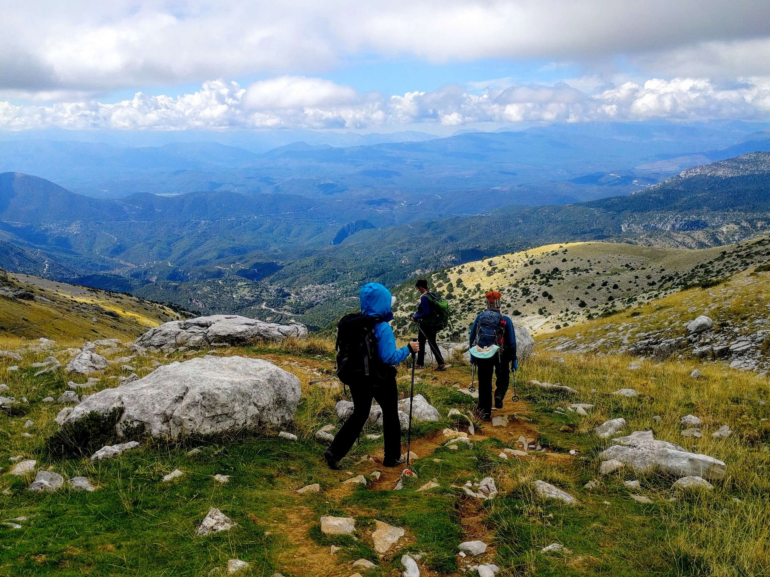 Three hikers walking down the mountain in Zagori Greece