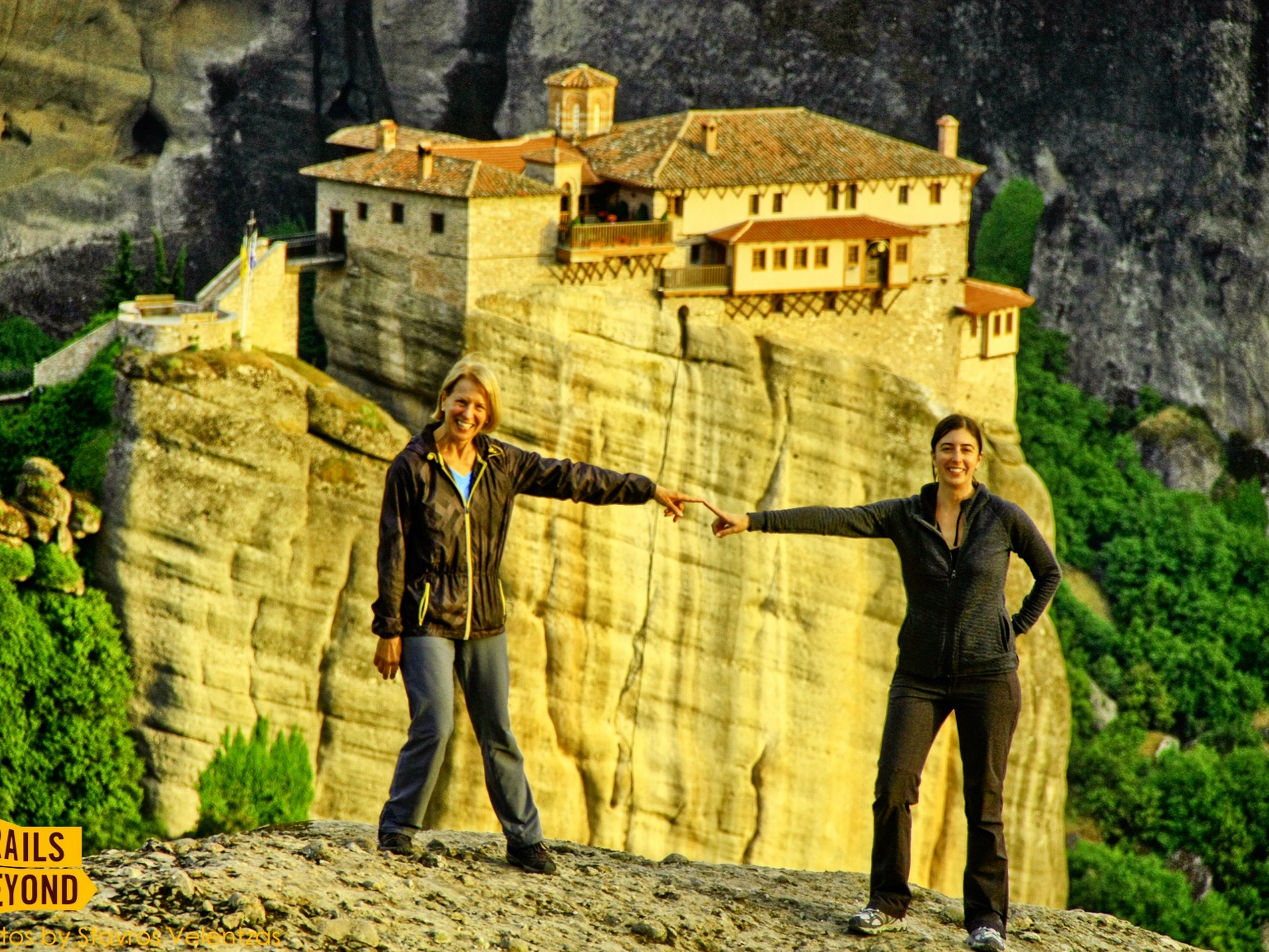 Two ladies posing in front of Meteora monastery