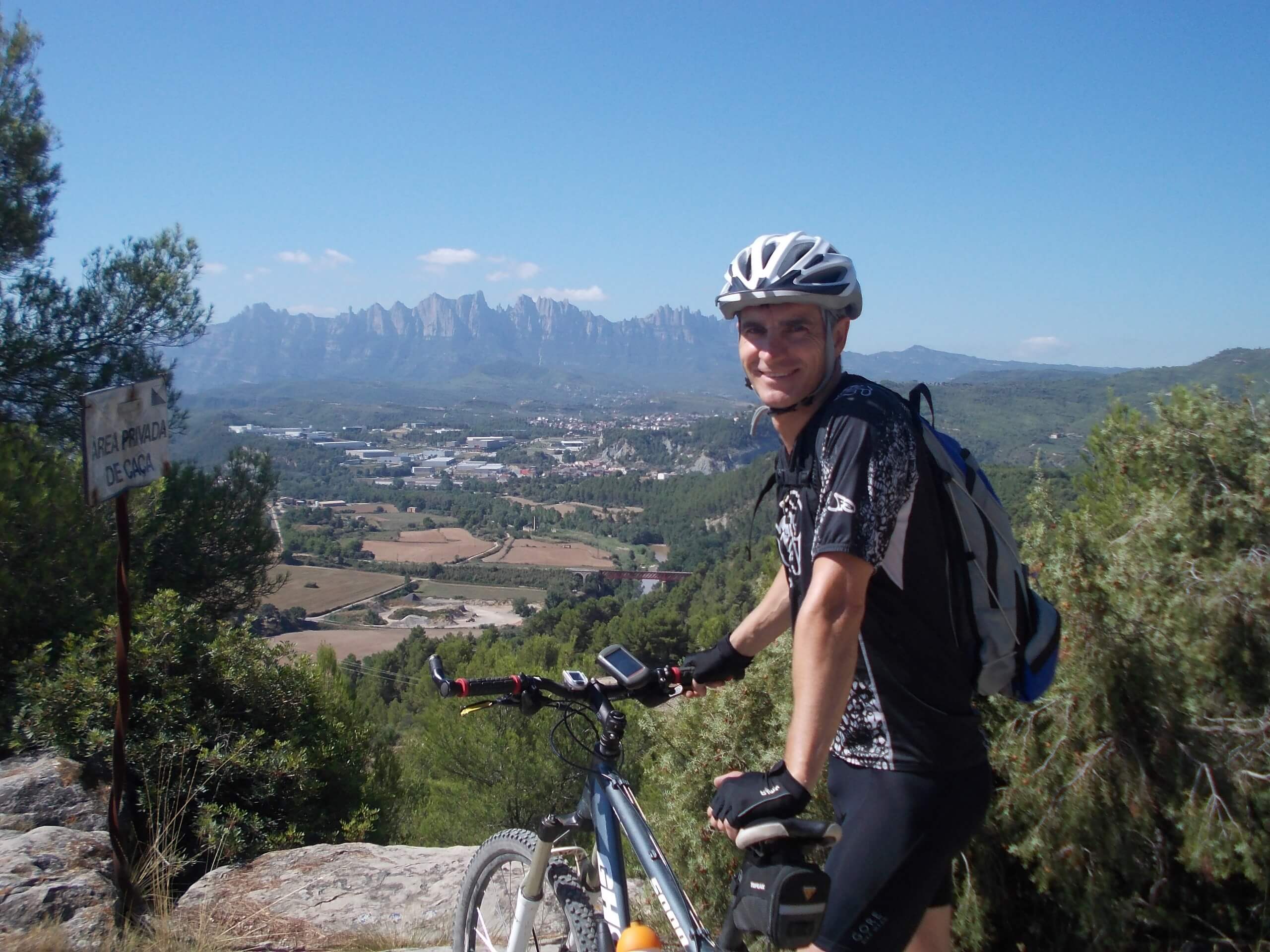 Biker with a bike at an overview in Spain