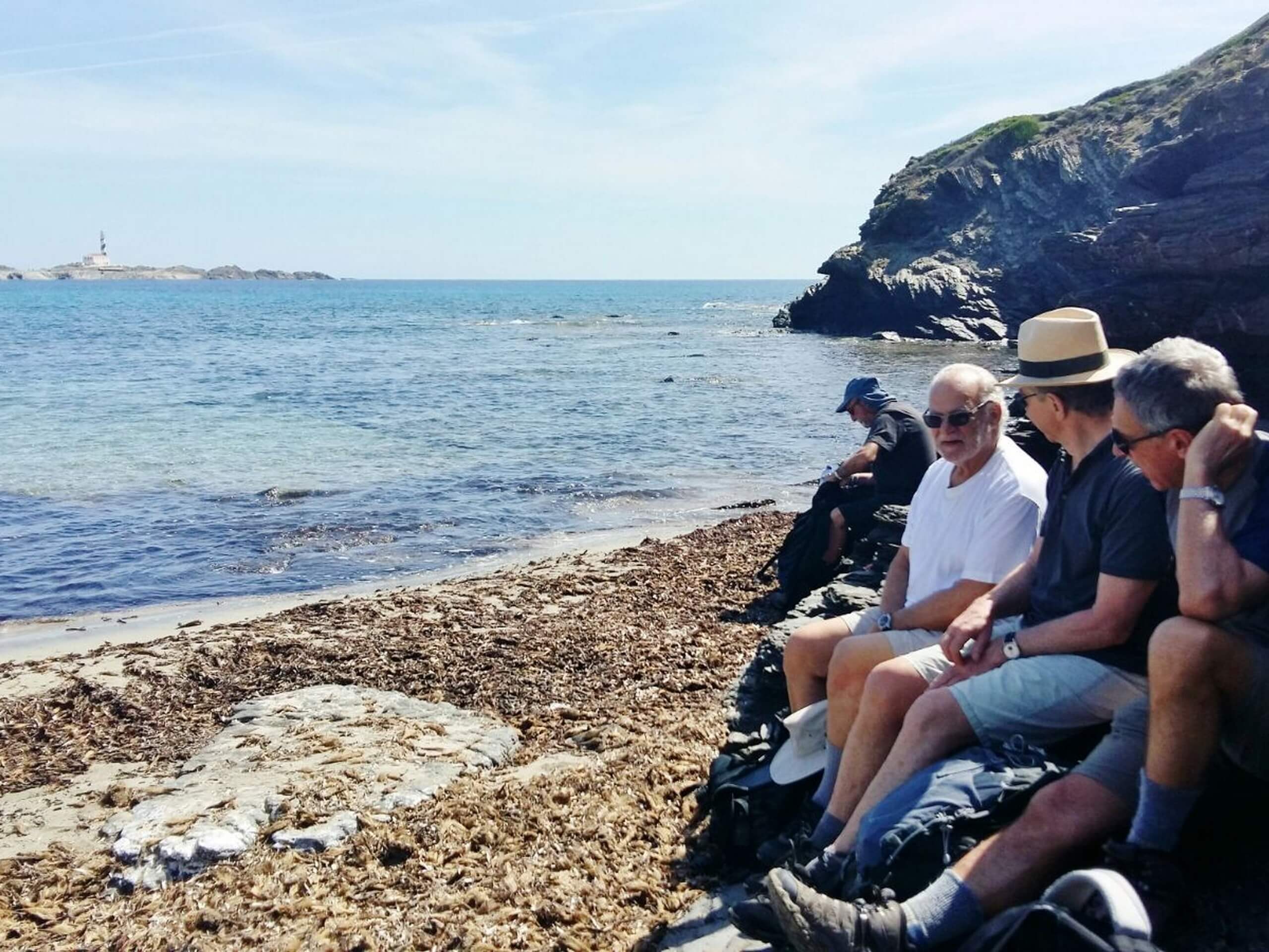 Group of hikers resting on the beach in Minorca