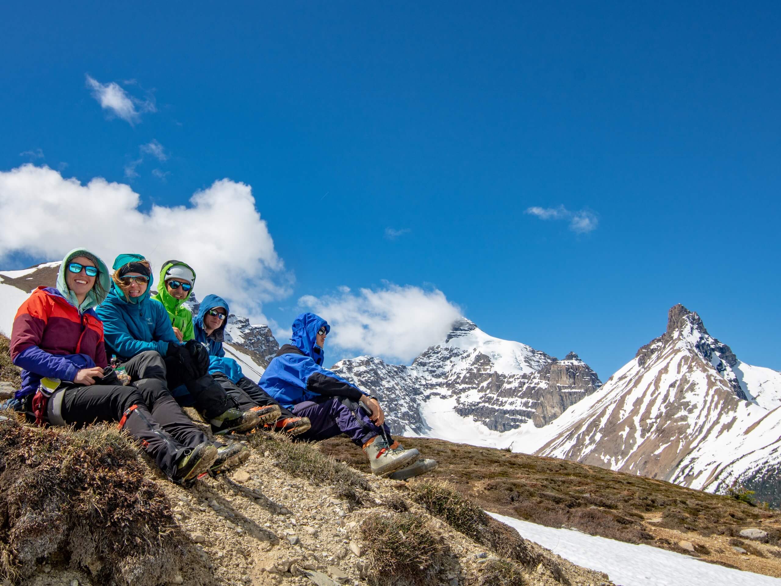 Group of climbers resting surrounded by snowy peaks while on ice and snow training course in the Canadian Rockies