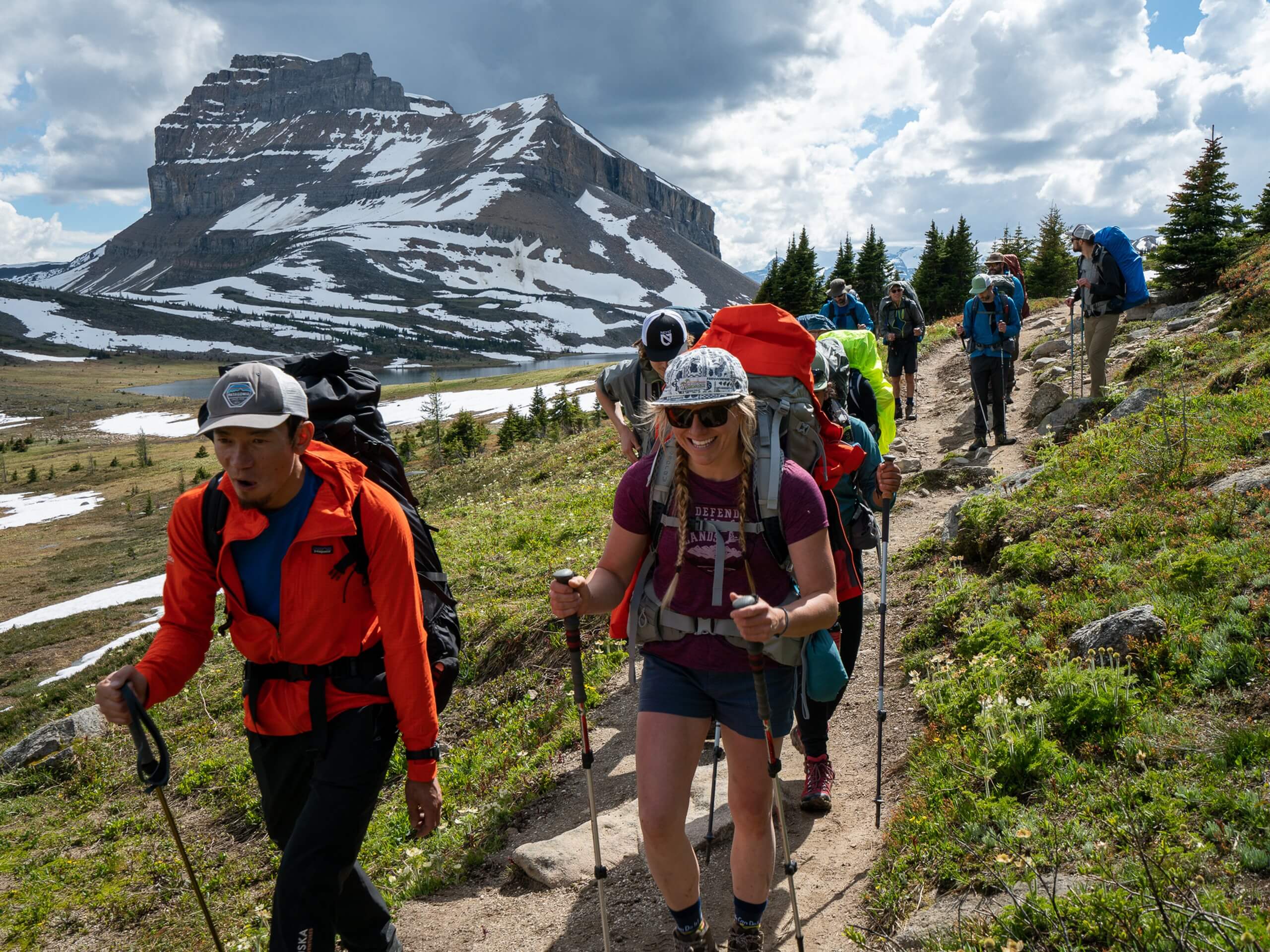 Group of backpackers walking in the Skoki Region with Mount Redoubt in the background
