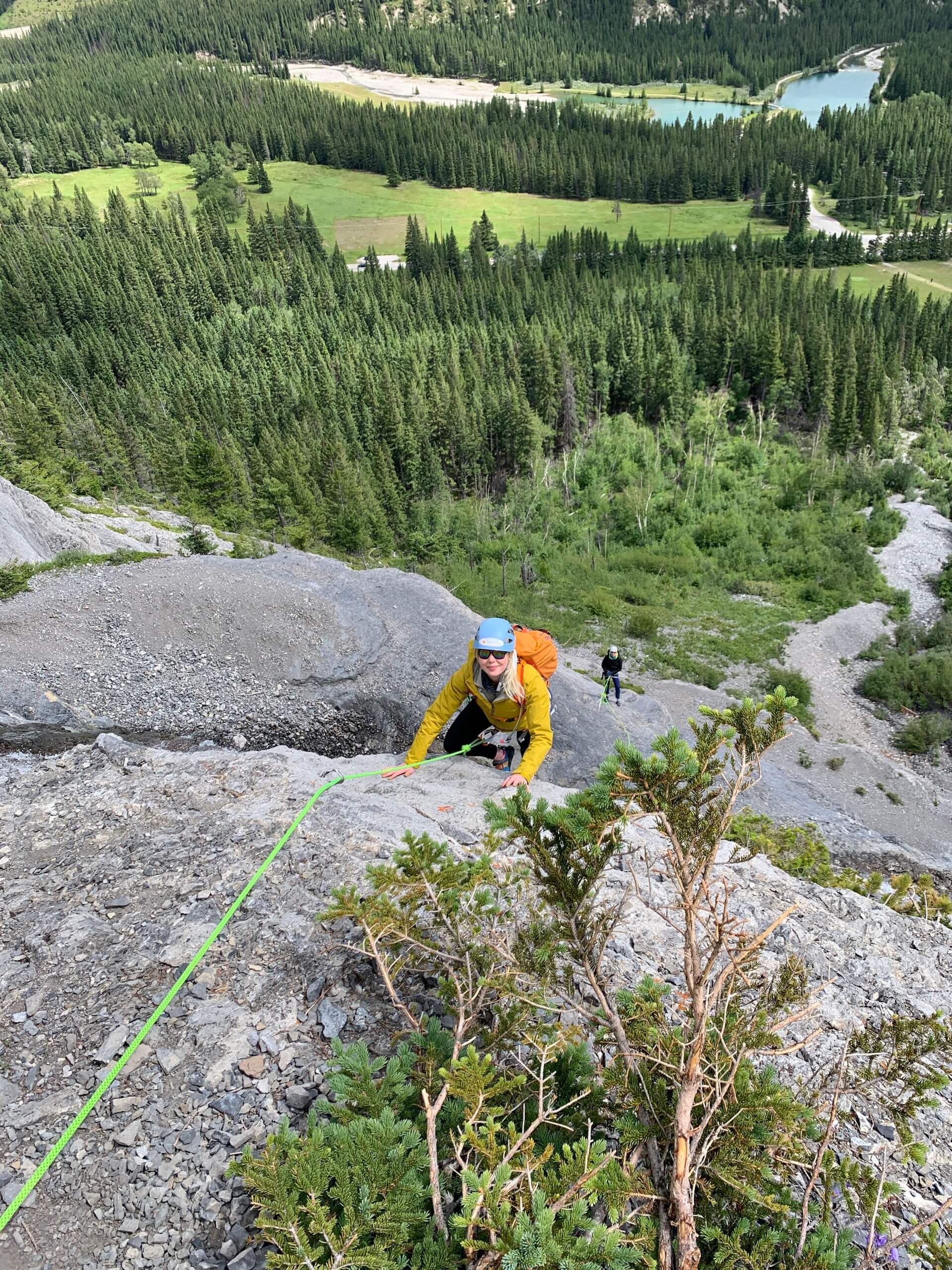 Guy climbing over the boulder while on rock climbing course near Canmore