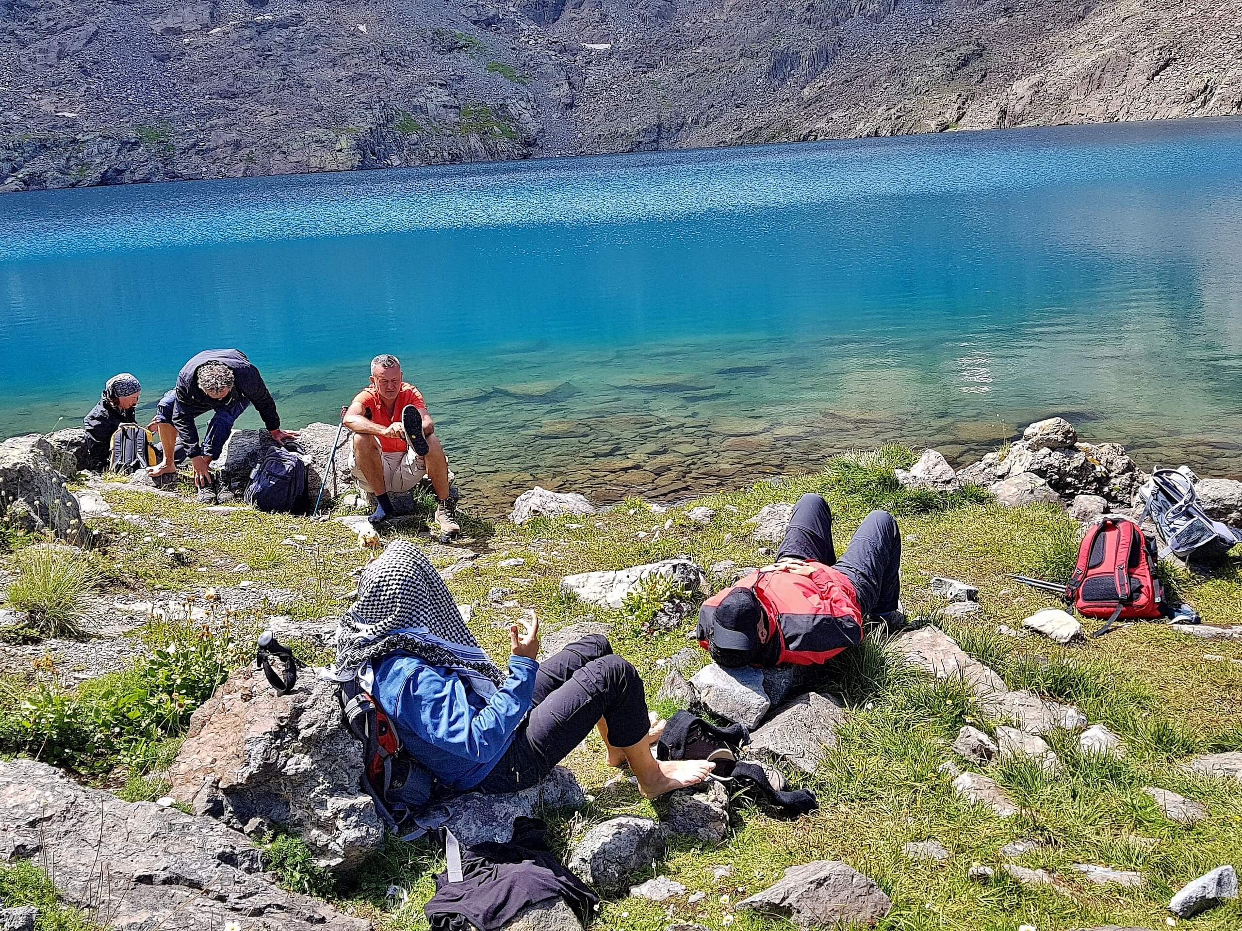 Group of hikers resting near the turqoise lake in Kackar Mountains