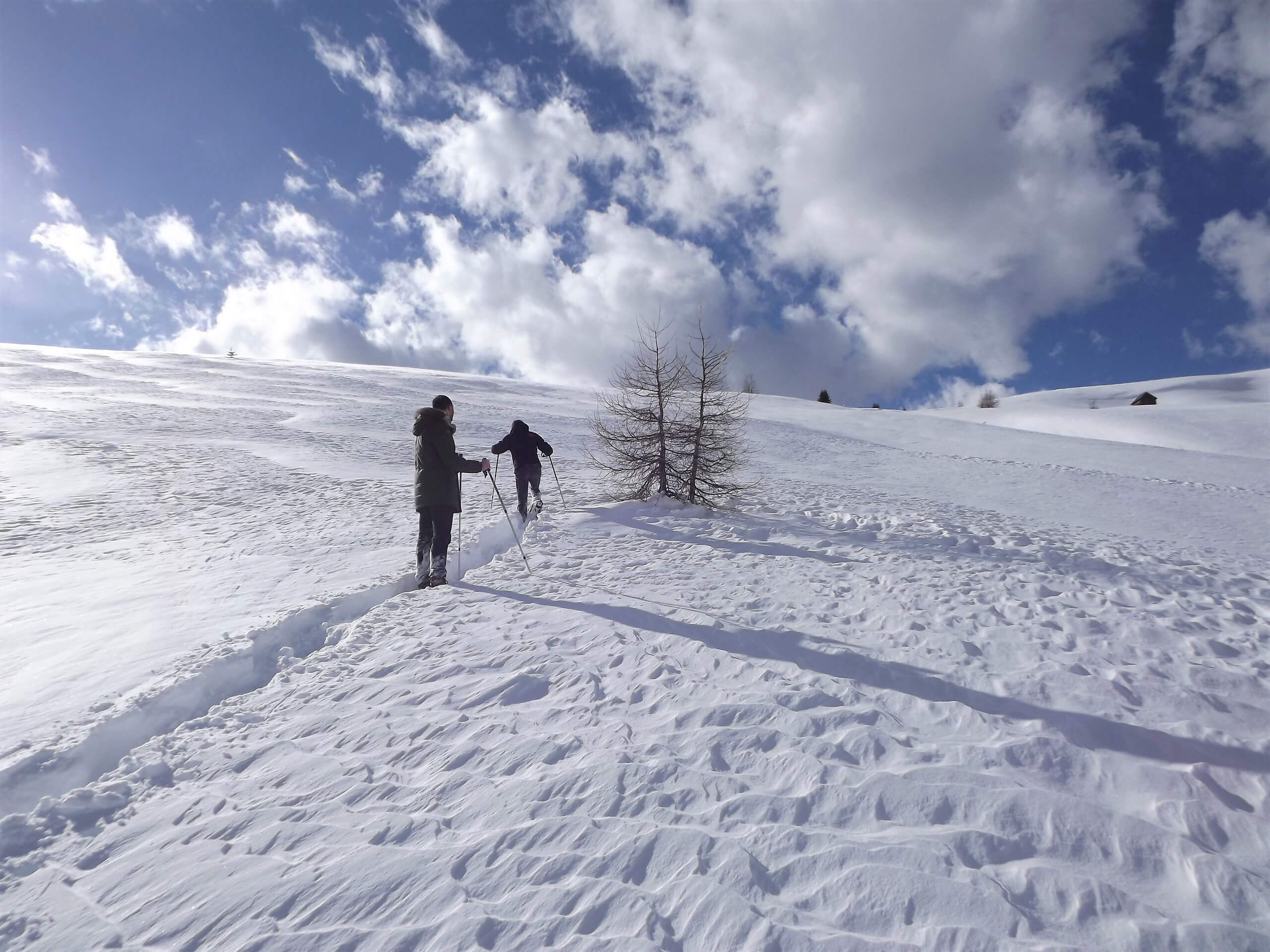 Two snowshoers ascending to the snowy mountain in Italy