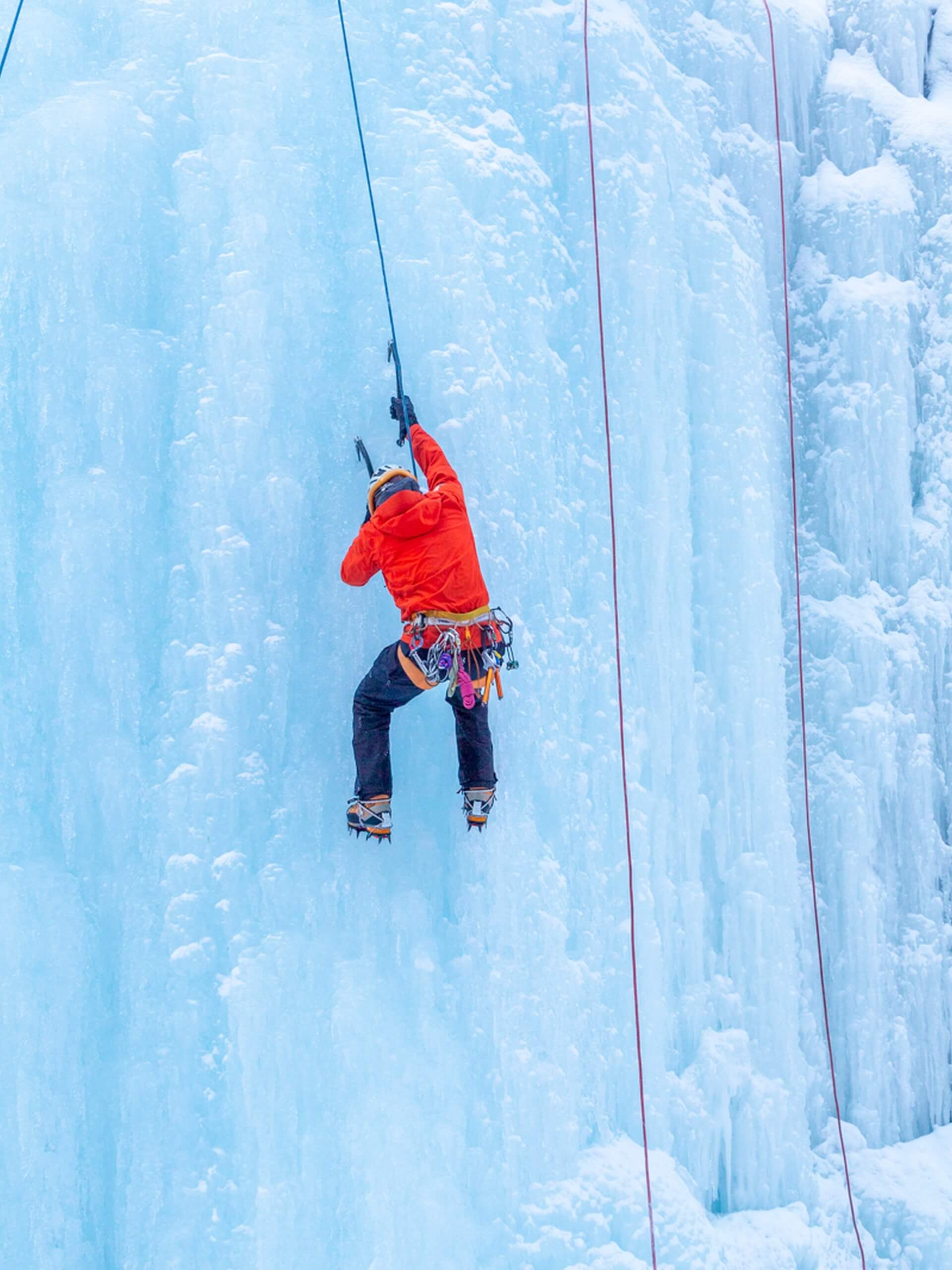 Ice climber ascending on a frozen waterfall in Johnston Canyon