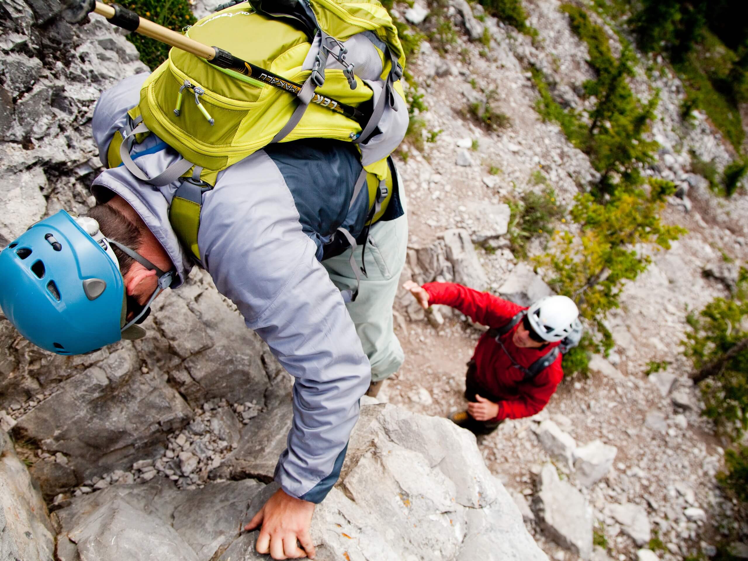 Two scramblers climbing up the rock wall