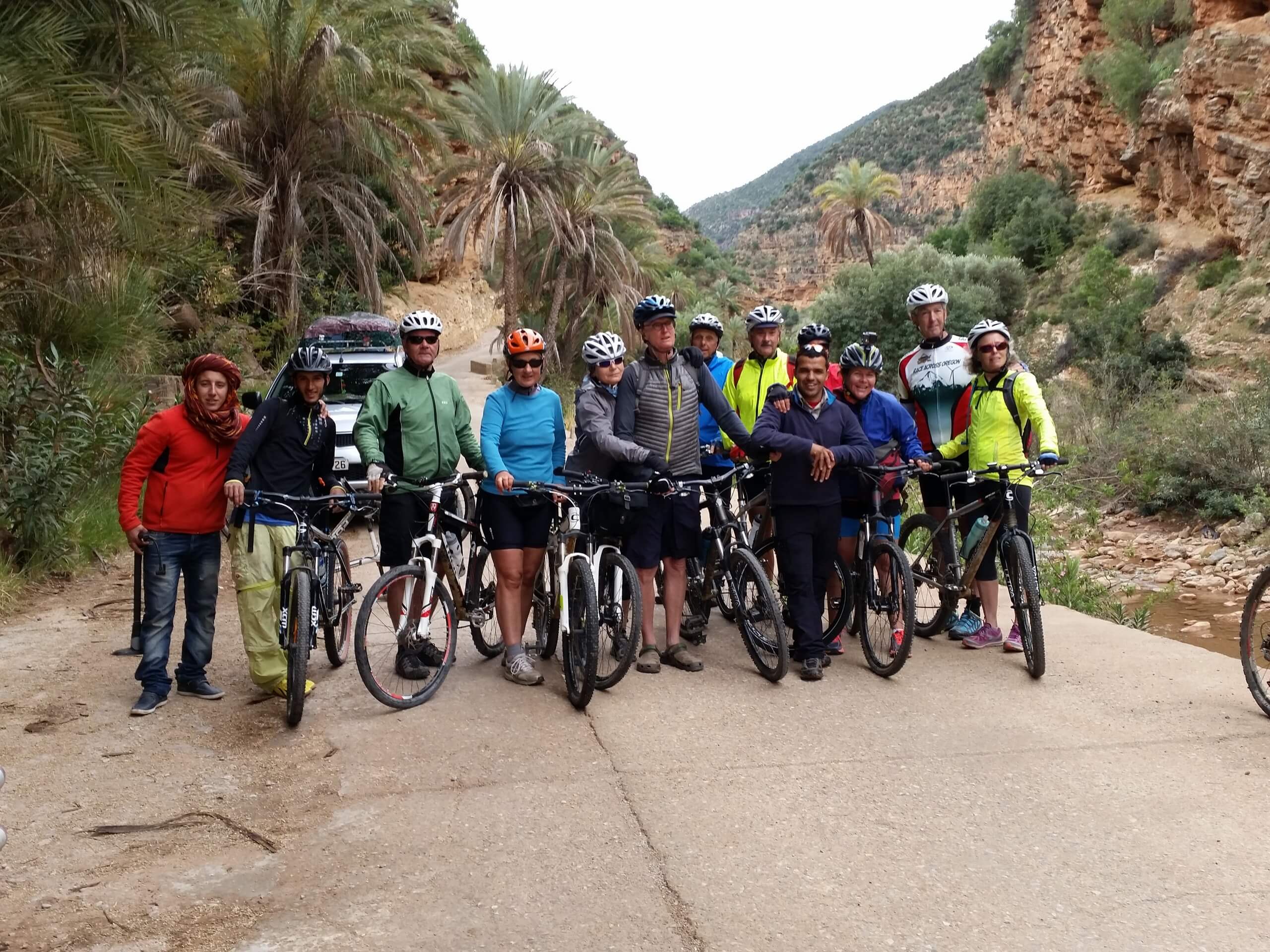 Group of mountain bikers posing on a gravel road in Morocco