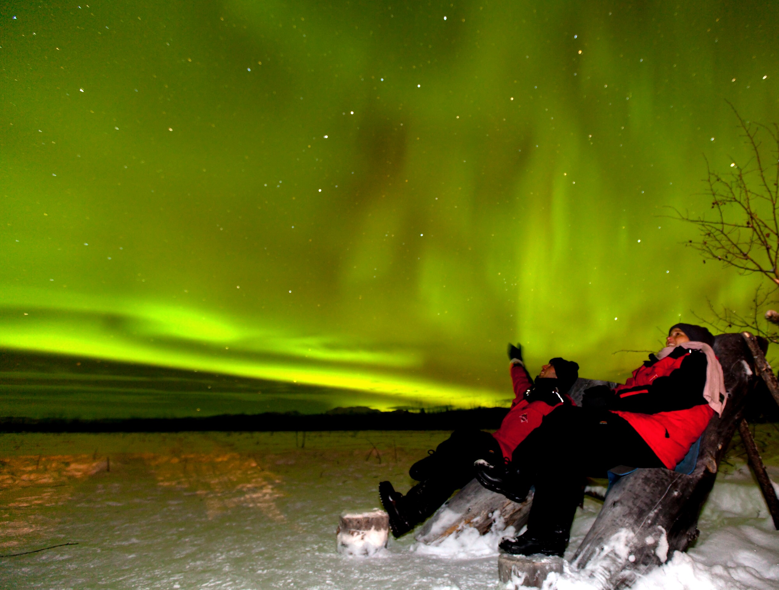 Couple watching the night sky with Northern Lights